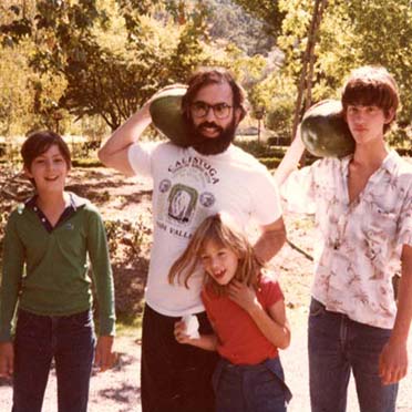 Francis Ford Coppola holding a watermelon, standing next to his children.
