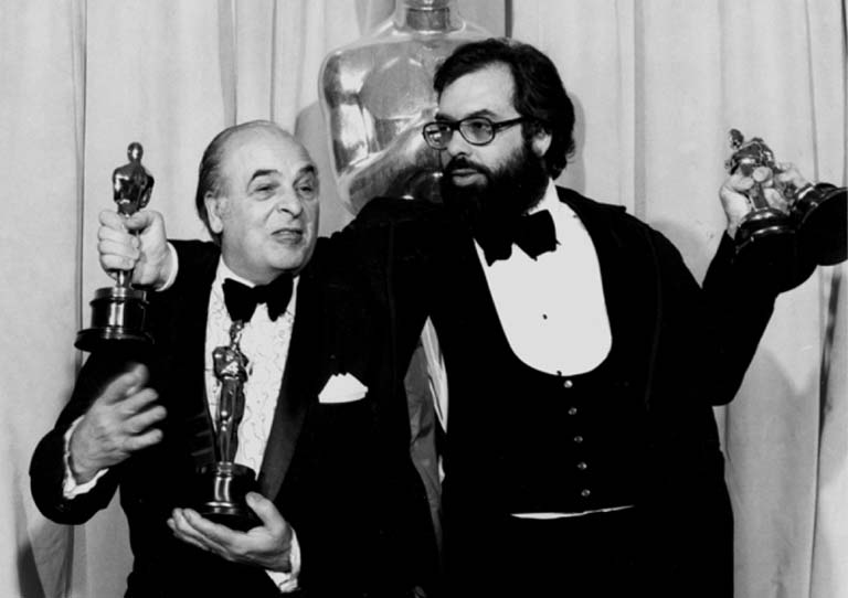 Francis Ford Coppola holding his Oscar awards.